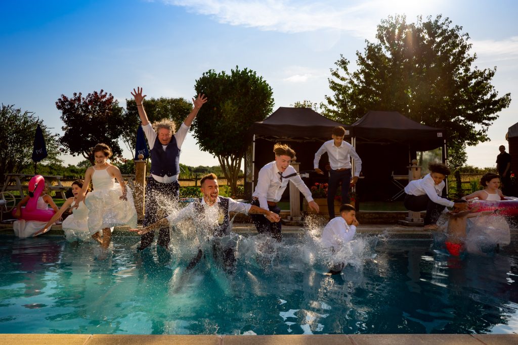 Wedding party jumping in pool