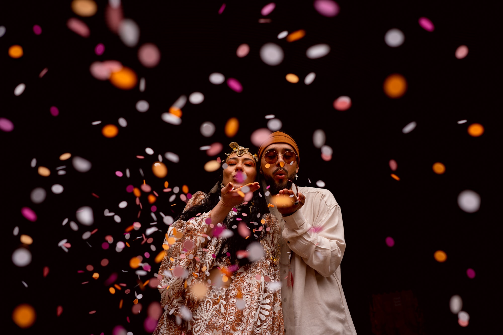 Couple blowing wedding confetti