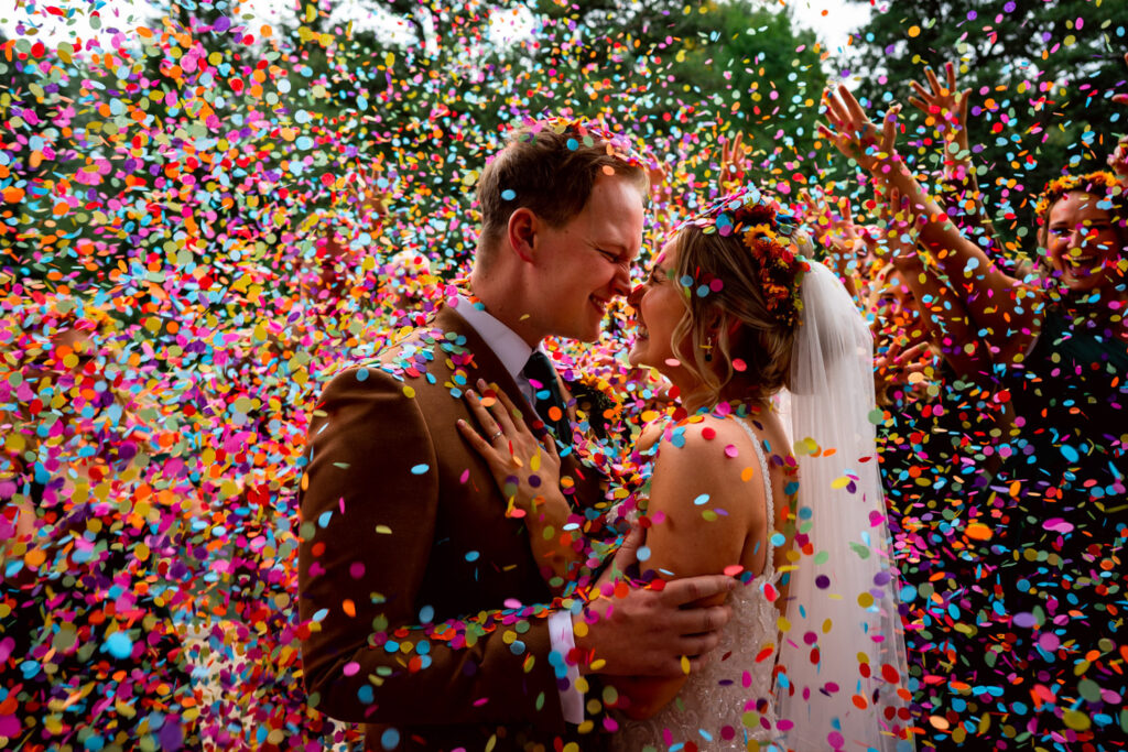 Couple in bright confetti by Birmingham wedding photographer