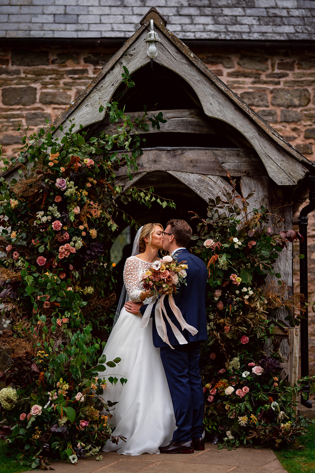 Bride and groom outside church with florals