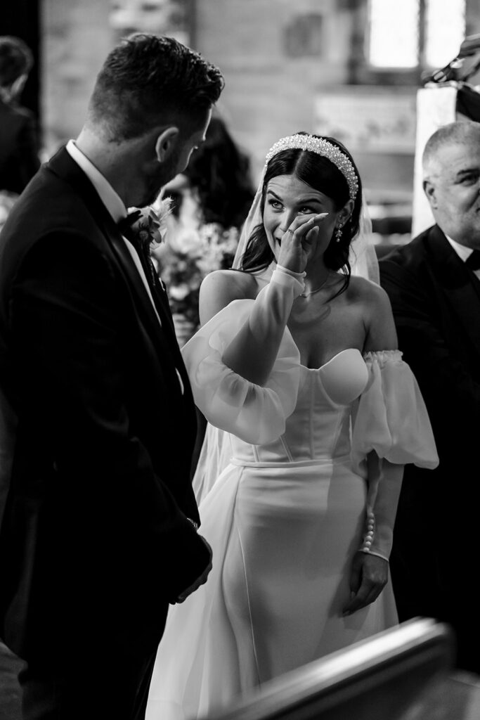 Fun wedding photographer as bride cries at alter