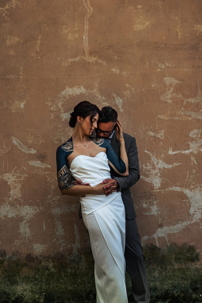 Wedding couple in front of wall with tattoos