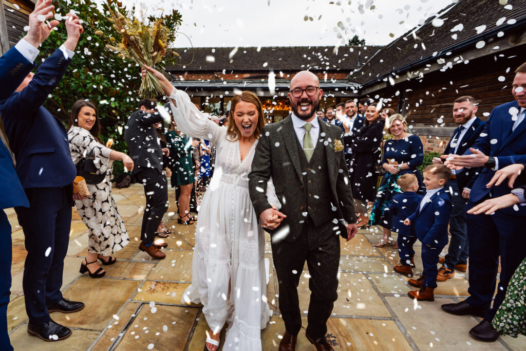 Wedding couple at Mythe Barn with confetti