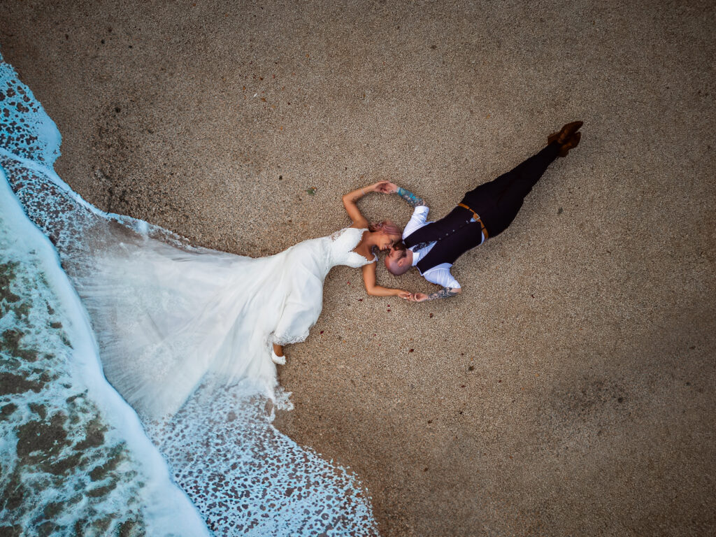 Different wedding photography of couple on beach with dress in water